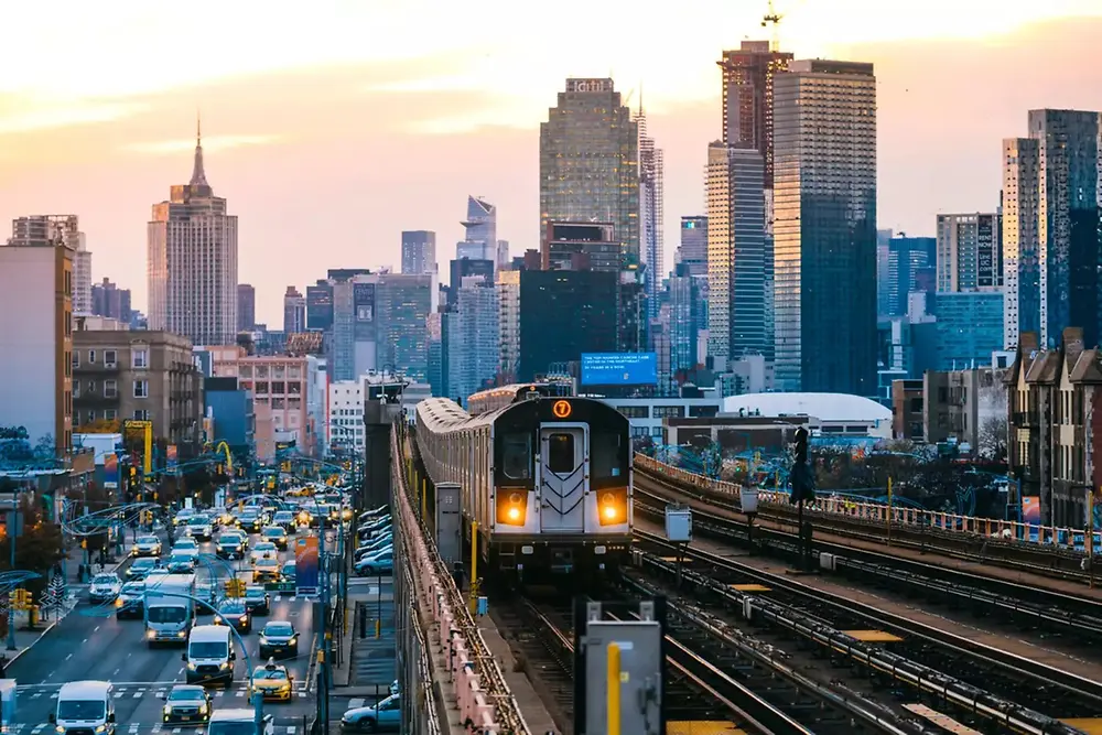 รถไฟในเมืองวิ่งผ่านเส้นขอบฟ้าของเมืองสมัยใหม่ในเวลากลางวัน